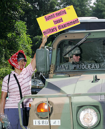 기지 안으로 들어서는 미군차량을 향해  항의피켓을 든 참가자. [사진-통일뉴스 김주영 기자]