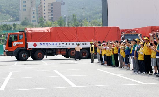 대한적십자사의 봉사단의 환송 받으며 통일공원 주차장을 빠져나가는 트럭들. [사진-통일뉴스 김주영 기자]