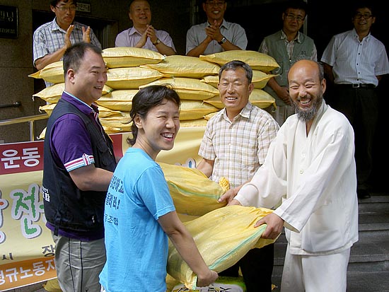 '전국농민회총연맹'(의장 문경식)이 29일 오전 11시 서울 영등포 민주노총 건물 앞에서 열린 이랜드 파업 승리를 위한 우리 쌀 전달식'을 갖고 공대위 측에 20kg 쌀 50여포대를 전달하고 있다. [사진제공-전농]