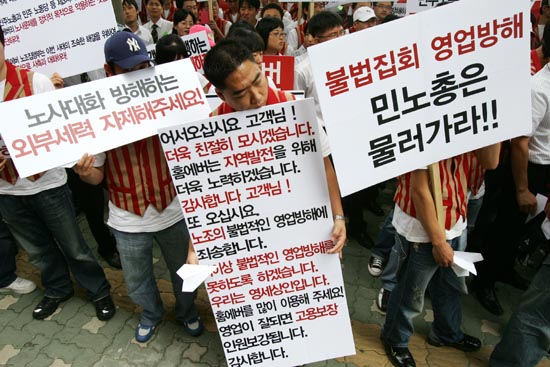 민주노총 앞에서 집회를 벌이는 홈에버 매장 직원들. 각자 들고 나온 피켓에는 사측 입장을 고스란히 담고 있다. 이랜드 측은 노동부의 중재로 이날 오후 7시 민주노총에서 노조측과 교섭을 재개하기로 했으나 노조측의'매출제로 투쟁'을 이유로 나타나지 않았다. [사진-통일뉴스 김주영 기자]