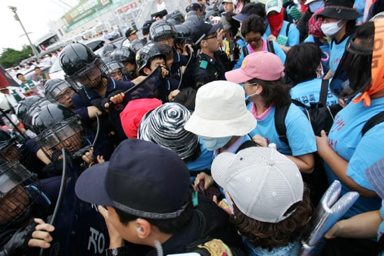 이랜드 노조원들이 예정된 집회장소로 이동하던 도중 경찰에 막혀 실랑이를 벌이고 있다. 노조원들은 경찰 뒤로 보이는 사측 직원들을 향해 이름을 부르며 