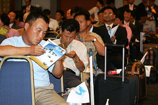 3일부터 7일까지 평양에서 진행되는 '남북농민연대모임' 참석자들이 비행기에 오르기 전 일정을 확인하고 있다.[사진-통일뉴스 김주영 기자]