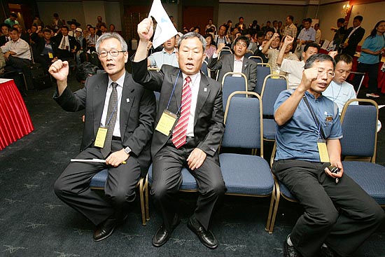 남측 단장을 맡은 6 .15 남측위 농민본부 정재돈 공동대표와 (왼쪽)문경식 공동대표(가운데)가  나란히 앉아 힘차게 구호를 외치고 있다.[사진-통일뉴스 김주영 기자]