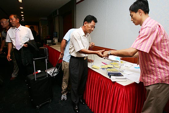 방북증명서와 명찰 등 물품을 받고 있는 참가단. [사진-통일뉴스 김주영 기자]