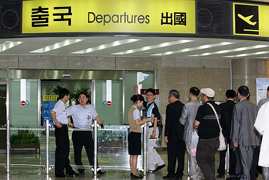 출국장을 빠져나가는 참가단이 단일기를 흔들어 보이고 있다.[사진-통일뉴스 김주영 기자]