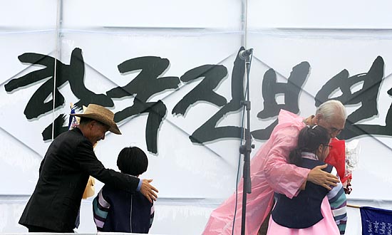 보석으로 풀려난 오종렬, 정광훈 상임공동위원장이 화동에게 환영의 꽃다발을 받아들고 있다. [사진-통일뉴스 김주영 기자]