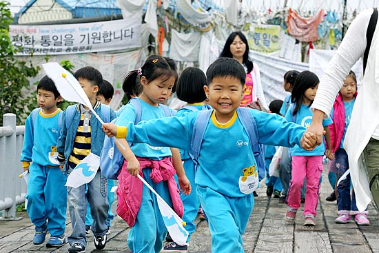 단일기를 나눠 받은 어린이들이 자유의 다리 위에서 뛰어놀며 즐거워 하고 있다. [사진-통일뉴스 김주영 기자]