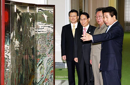 오전 1차 회담에 앞서 노 대통령이  김 위원장에 선물한 통영 나전칠기로 만든 12장생 병풍에 대한 설명을 하고 있다. [사진-청와대 사진기자단]