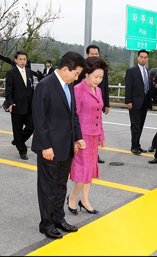 '역사적 순간을 천천히'. 노무현 대통령과 권양숙 여사가 군사분계선을 넘기 앞서 잠시 멈춰 서 내려다보고 있다. [사진-청와대 사진기자단]