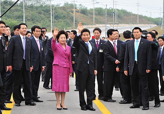 군사분계선을 넘어선 대통령 일행이 취재진들을 향해 손을 흔들어 보이고 있다. [사진-청와대 사진기자단]