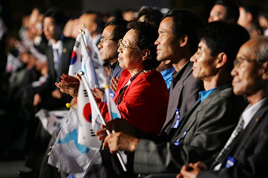 대통령의 정상회담 결과 발표를 진지하게 듣고 환영객들. 중간 중간 격려의 박수가 이어졌다. [사진-통일뉴스 김주영 기자]