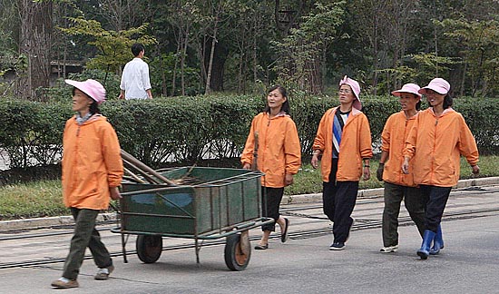 4일 거리미화원들이 손수레에 비를 싣고 평양시내를 걷고있다. [청와대사진기자단]