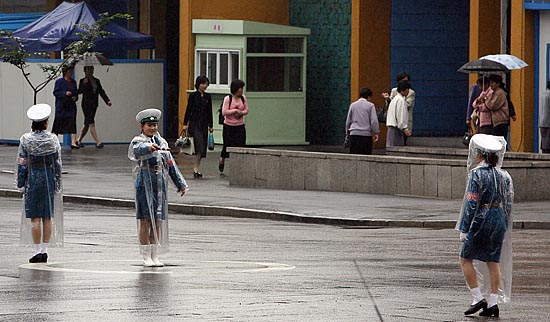 3일 오후  평양시내 창광거리에  보슬비가 내리고 있는 가운데 여성교통안전 보안원들이 분주히 차량을 정리하고 있다. [사진-청와대 사진기자단]
