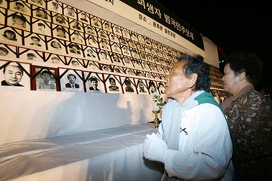 추모제를 마치고 이어진 헌화에는 열사들의 유가족들의 헌화가 이어졌다. 영정사진을 물끄러미 쳐다보는 유가족.[사진-통일뉴스 김주영 기자]