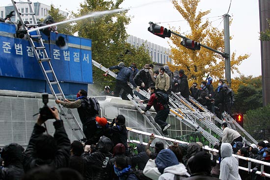 종로를 통과해 광화문으로 나서는 일부 참가자들이 경찰 바리케이트를 사다리로 넘고 있다. [사진-통일뉴스 김주영 기자]