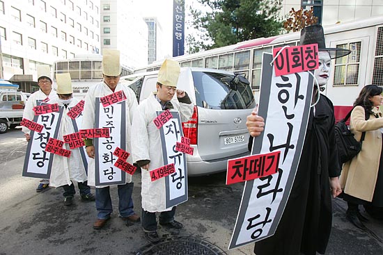 21일 오전 낮12시 서울 여의도 한나라당사 앞에서 각계 단체들의 집회가 연이은 가운데 한국진보연대가 한나라당사 앞에서 부패정당 한나라당 이명박 후보 사퇴를 요구하며 한나라당의 '변천사'를 보여주는 퍼포먼스를 벌이고 있다. [사진-통일뉴스 김주영 기자]