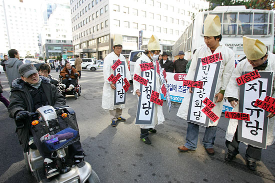 집회를 마친 '장애인차별철패연대' 소속 참가자들이 응원의 박수를 보내고 지나고 있다. [사진-통일뉴스 김주영 기자]