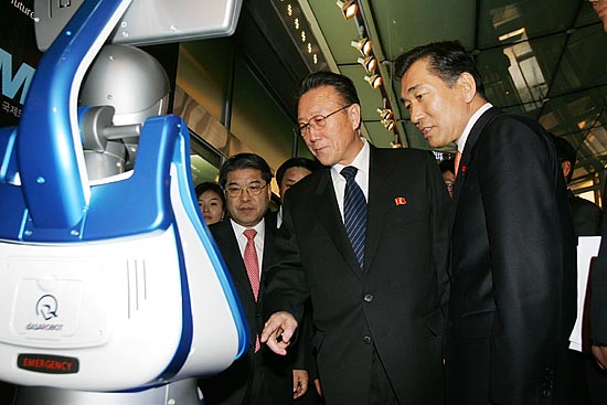 인천 경제자유구역 홍보관 시찰에 나선 김양건 통전부장이 홍보용 로봇 '장금이'를 시범사용해 보고 있다. [사진-통일뉴스 김주영 기자]