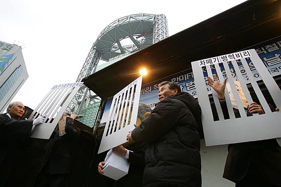 1일 오후 서울 종로 보신각에서 열린 제2차 범국민행동의 날 집회에서 삼성 이건희 회장과 BBK 주가조작 연루의혹을 받고 있는 이명박 후보, 비리 후보로 비난 받고 있는 이회창 후보가 감옥에 갇히는 퍼포먼스를 벌이고 있다. 집회 장소 뒤로는 삼성증권 건물이 보인다. [사진-통일뉴스 김주영 기자]