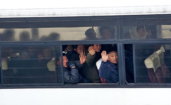 버스를 타고 일터로 향하는 평양시민들이 밝은 표정으로 손을 흔들어 보이고 있다. [사진-통일뉴스 김주영 기자]