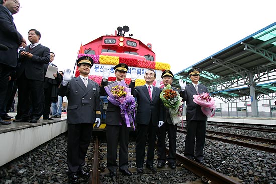 첫 운행에 나설 화물열차 앞에서 취재진을 향해 포즈를 취하는 기관사들과 이철 사장.[사진-통일뉴스 김주영 기자]