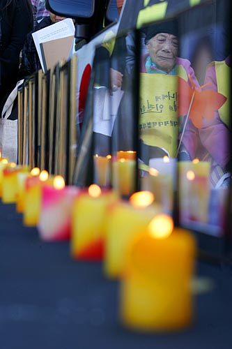 먼저 눈을 감으신 할머니들의 영정사진으로 최고령의 '위안부'피해자 이순덕 할머니가 눈물을 흘리는 모습이 비친다. 이순덕 할머니는 내년이면 92세가 된다. [사진-통일뉴스 김주영 기자]