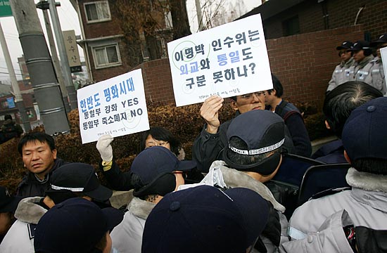 인수위 건물 정문 앞에서 기자회견을 진행하려던 참가자들이 경찰에 둘러싸여 있다.[사진-통일뉴스 김주영 기자]