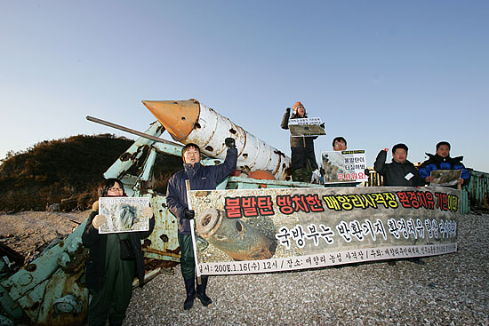 농섬을 찾은 '평화와통일을여는사람들' 소속 회원들이 사격 목표물 앞에서 구호를 외치고 있다. [사진-통일뉴스 김주영 기자]