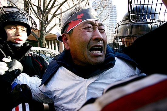 '난 여기서 죽을테야!'. 도로로 뛰쳐나온 주민을 경찰이 저지하고 있다. [사진-통일뉴스 김주영 기자]