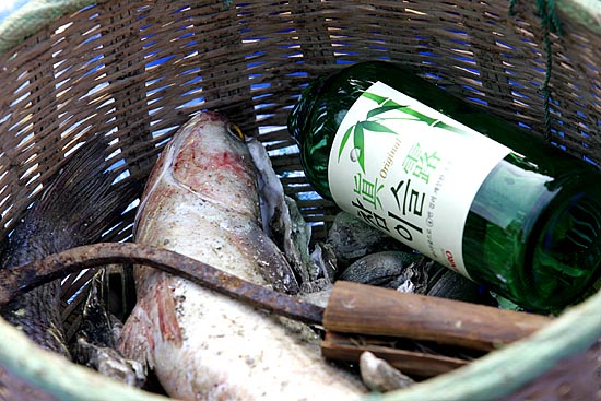 태안주민들이 가져온 해산물 망루. 이제는 언제 쓸지 모르는 굴 까는 호미가 깨진 소주병 옆에 나뒹굴고 있다. [사진-통일뉴스 김주영 기자]