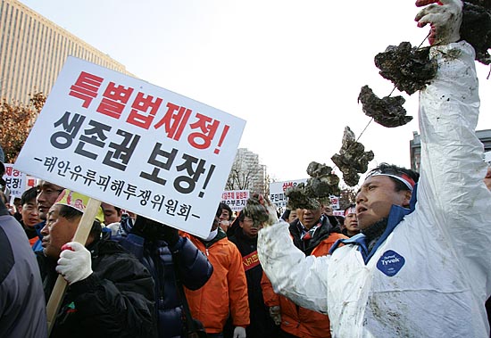 집회를 마친 태안주민들이 기름 범벅이 된 굴 등 해산물을 들고 태평로 삼성본관으로 행진을 시도하고 있다. [사진-통일뉴스 김주영 기자]