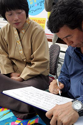 방명록에 격려의 글을 쓰고 있는 이석행 민주노총위원장. 이 위원장은 정 위원장의 건강이 걱정돼 병원진료까지 예약해 주었다. [사진-통일뉴스 조성봉 기자]