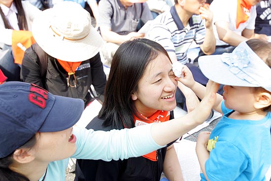 엄마의 땀을 휴지로 닦아주는 어린아이.[사진-통일뉴스 조성봉 기자]