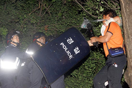 버스위에 올라간 시민을 전경이 방패로 위협하고 있다.[사진-통일뉴스 조성봉 기자]