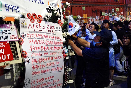 국화로 '꽃단장'을 한 전경버스에 한 참가자가 태극기를 꽂고 있다.[사진-통일뉴스 한준기 객원기자]