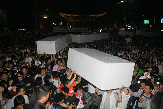 '6.10 100만 촛불대행진'에 참석했던 시민들이 11일 새벽 세종로네거리를 막고 있는 컨테이너 앞에 스티로폼을 쌓아 올리려 하고 있다.[사진-통일뉴스 조성봉 기자]