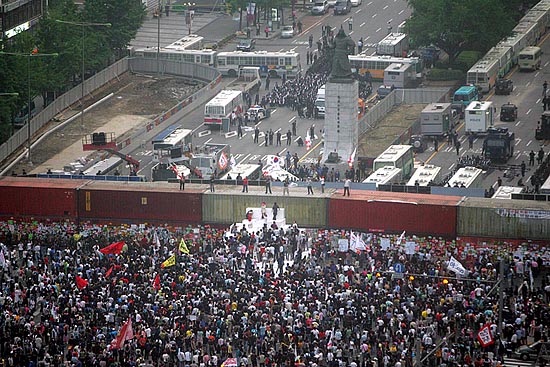 시민들이 끝내 '명박산성'을 점령했다.'6.10 100만 촛불대행진'을 막기 위해 경찰이 쌓아놓은 대형 컨테이너 장벽 위에서 태극기를 중심으로 한 깃발 수십 기가 휘날렸다. [사진-통일뉴스 조성봉 기자]