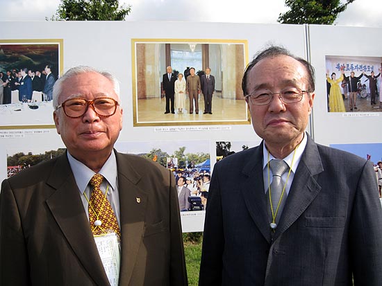 6.15 정상회담 당시 민주평통 수석부위원장이었던 김민하(왼쪽) 선생이 권상능 조선화랑 대표와 감회에 젖어 기념촬영을 하고 있다. 뒷편 사진에 김정일 국방위원장과의 기념사진이 보인다. [사진제공-6.15남측위]