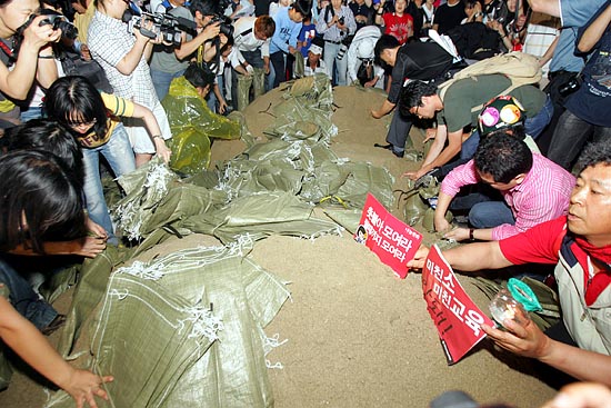 '국민토성'을 쌓기 위해 시민들이 모래를 포대에 담고 있다. [사진-통일뉴스 조성봉 기자]