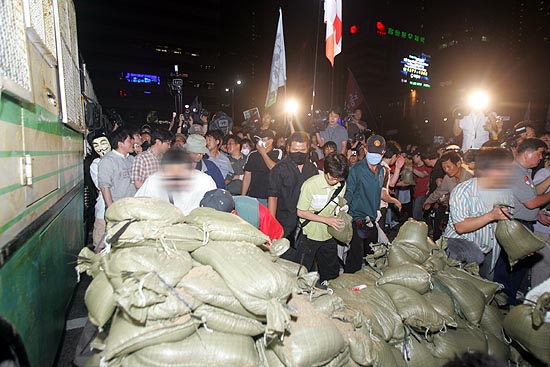 21일 밤 광화문 네거리에서 촛불집회 참가자들이 경찰의 전경버스 바리케이트에 맞서 '국민토성'을 쌓고 있다.[사진-통일뉴스 조성봉 기자]