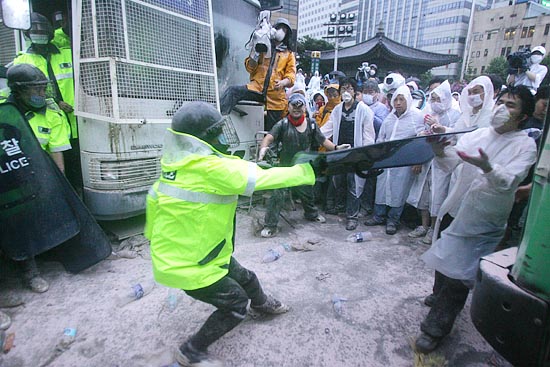 경찰이 시민과 대치 도중 방패로 목 부위를 위협하고 있다.[사진-통일뉴스 조성봉 기자]