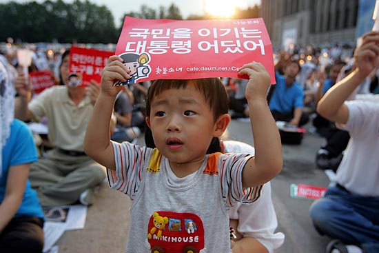 엄마와 함께 촛불문화제에 참가한 한 어린아이가 손 피켓을 들고 서 있다.[사진-통일뉴스 조성봉 기자]