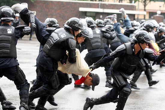 시위대의 팔을 꺽고, 사지를 들어서 연행해 가는 모습을 시연하는 기동대원들. [사진-통일뉴스 조성봉 기자]