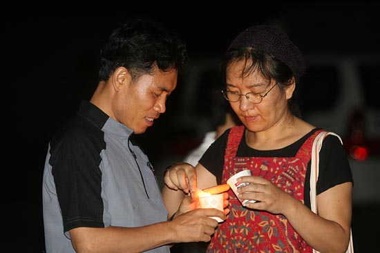 '무건리 훈련장 확장 반대'를 위해 촛불을 서로 서로 건네고 있는 참가자들.[사진-통일뉴스 조성봉 기자]