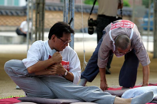 '부시 반대! 이명박 심판! 촛불 승리를 위한 1080배'를 올리기 위해 몸을 풀고 있는 촛불 수배자들.[사진-통일뉴스 조성봉 기자]