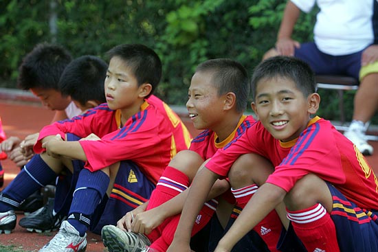 헤딩을 하며 눈을 감는 양측 선수들을 바라보고 웃고 있는 민족학교 어린이들. [사진-통일뉴스 조성봉 기자]