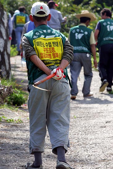 행사에 참가한 전국민주연합노동조합원들이 낫을 들고 열사묘역으로 올라가고 있다.[사진-통일뉴스 조성봉 기자]