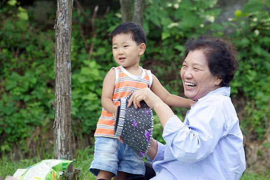 아이의 재롱에 웃고 있는 배은심 이한열 열사 어머니.[사진-통일뉴스 조성봉 기자]