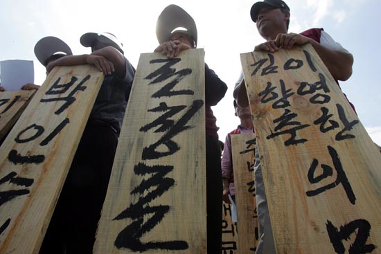 더운 날씨에도 불구하고 묘비를 들고 자리를 지킨 주민들.[사진-통일뉴스 조성봉 기자]