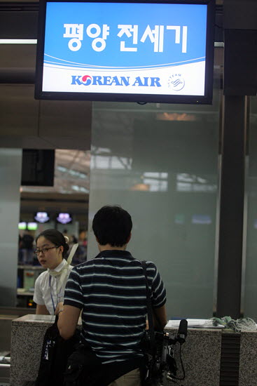 참가자들의 촬영을 마치고 뒤늦게 탑승수속을 받고 있는 참가자.[사진-통일뉴스 조성봉 기자]